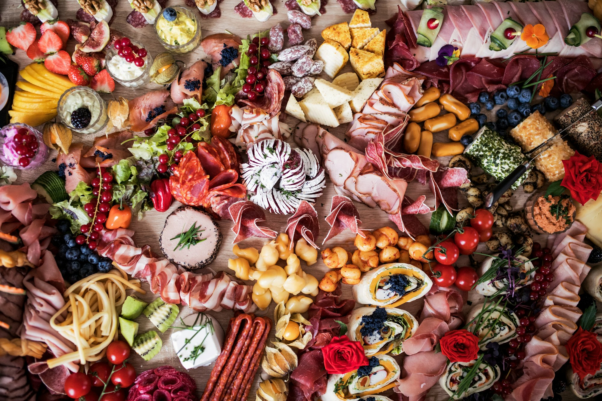 A top view of various food and snacks on a tray on a indoor party, a cold buffet.